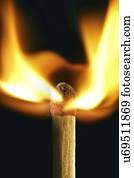Matchstick on fire against a black background.