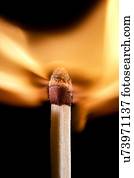 Matchstick on fire against a black background.