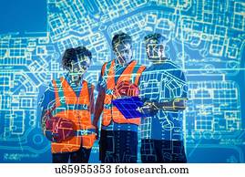 Engineers in discussion with projected plans