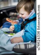 Boy in car using digital device