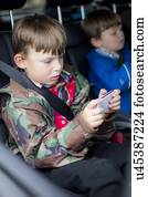 Boy in car using digital device