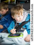 Boy in car with a digital device