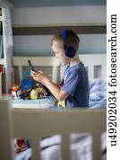 Boy wearing headphones using device