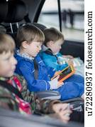 Three brothers in car with digital device