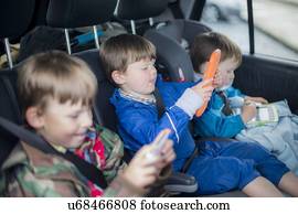 Three brothers in car with digital device