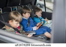 Three brothers in car with digital device