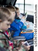 Three brothers in car with digital device