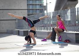 Woman in yoga position with friend
