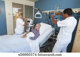 Nurses working with senior man