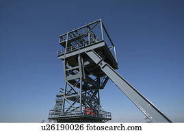 Mine shaft lift against clear blue sky.