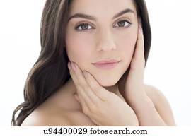 Woman with brown hair with hands on face