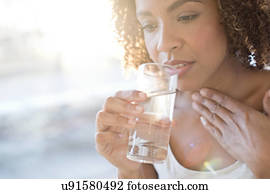 Mid adult woman drinking water