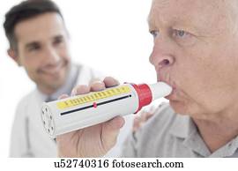 Senior man using peak flow metre