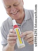 Senior man using peak flow metre