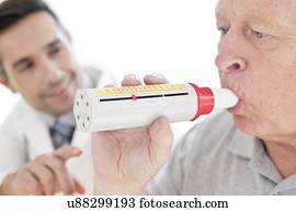 Senior man using peak flow metre