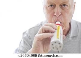 Senior man using peak flow metre