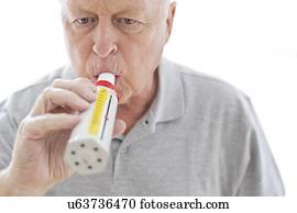 Senior man using peak flow metre