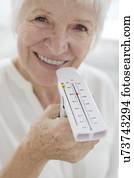Senior woman holding peak flow metre