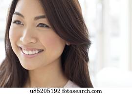 Woman with brown hair smiling and looking away