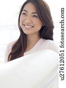 Woman with brown hair smiling and looking away