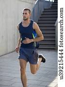 Young man running past steps.