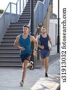 Young men running past steps.