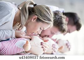 Doctor practising infant CPR on training dummies.