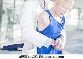 Doctor practising the Heimlich manoeuvre on a training dummy.