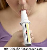 Woman using a peak flow metre.