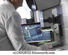 engenheiro, usando, um, estéreo, microscópio, para, inspeccionar, um, circuito impresso, durante, a, controle qualidade, process.