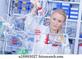 Laboratory assistant with chemical experiment.