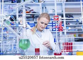Laboratory assistant with chemical experiment.