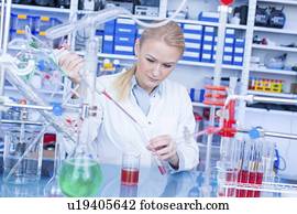 Laboratory assistant with chemical experiment.