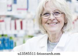 Portrait of smiling senior female pharmacist standing in pharmacy.