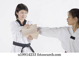 Female karate instructor teaching martial arts to a young woman Stock