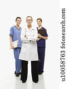 Full-length portrait of Caucasian women healthcare workers in uniforms standing against white background.