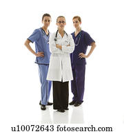 Full-length portrait of Caucasian women healthcare workers in uniforms standing against white background.