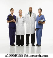 Full-length portrait of African-American man and Caucasian women medical healthcare workers smiling in uniforms standing against white background.