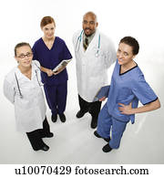 Full-length portrait of African-American man and Caucasian women medical healthcare workers smiling in uniforms standing against white background.