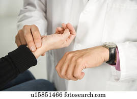 Doctor taking patient's pulse.
