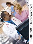 A Doctor And Nurse Discussing Something At The Reception Area Of A Hospital