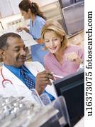 A Doctor And Nurse Discussing Something At The Reception Area Of A Hospital