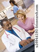 A Doctor And Nurse Discussing Something At The Reception Area Of A Hospital