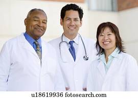 Three Doctors Standing Outside A Hospital