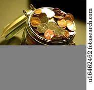 closeup of coins in and around jar