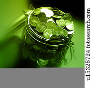 closeup of coins in and around jar