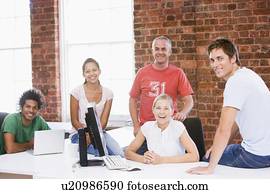 Five businesspeople in office space smiling