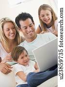 משפחה, ב, סלון, עם, מחשב נייד, לחייך