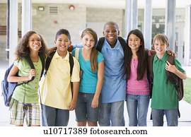 Six students standing outside school together smiling Six students standing outside school together smiling