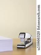 A Silver Stapler And A Pile Of Paperwork